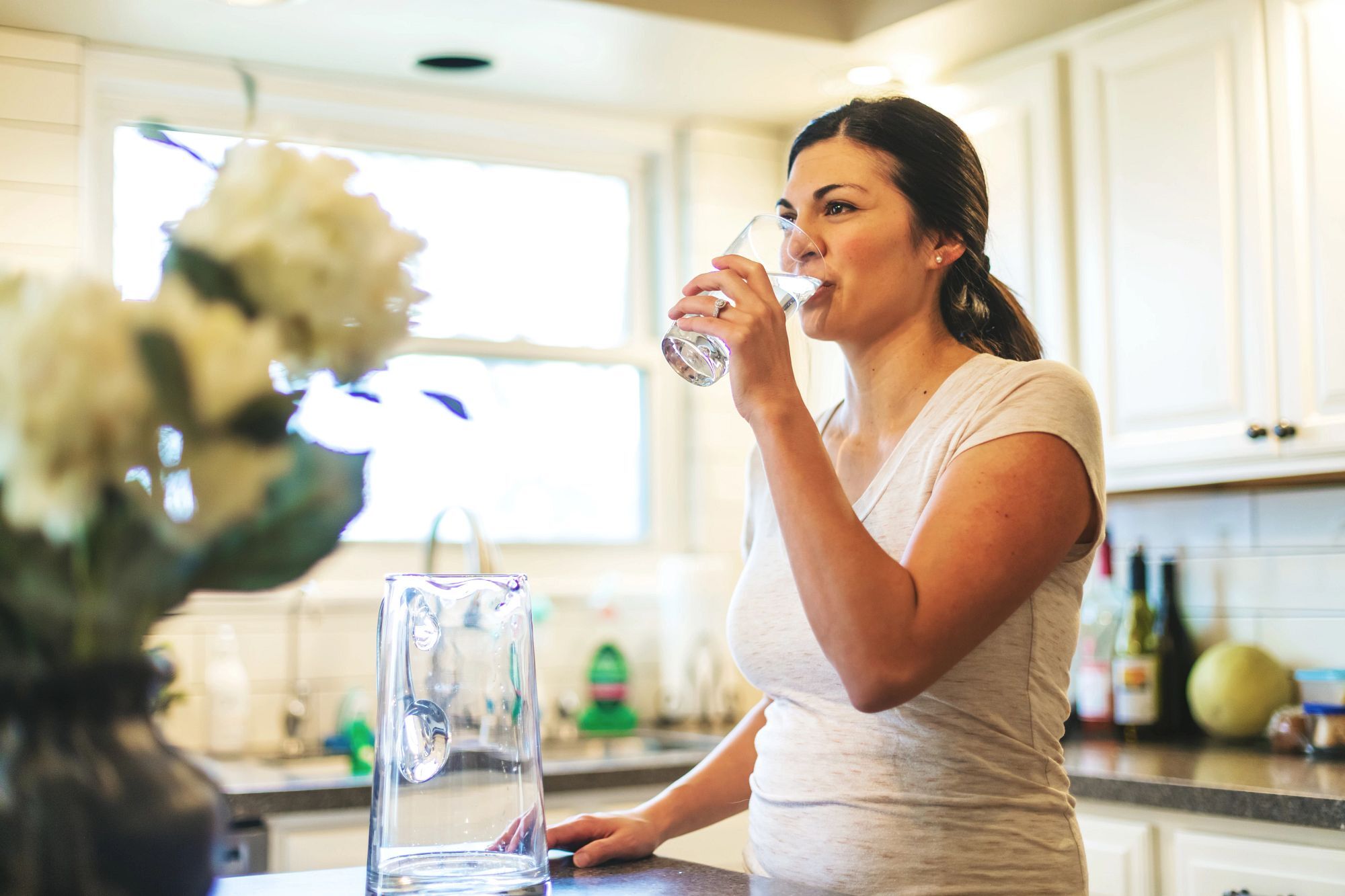 Beautiful Young Adult Filipino Millennial Female using water in residential home (Shot with Canon 5DS 50.6mp photos professionally retouched - Lightroom / Photoshop - original size 5792 x 8688 downsampled as needed for clarity and select focus used for dramatic effect)