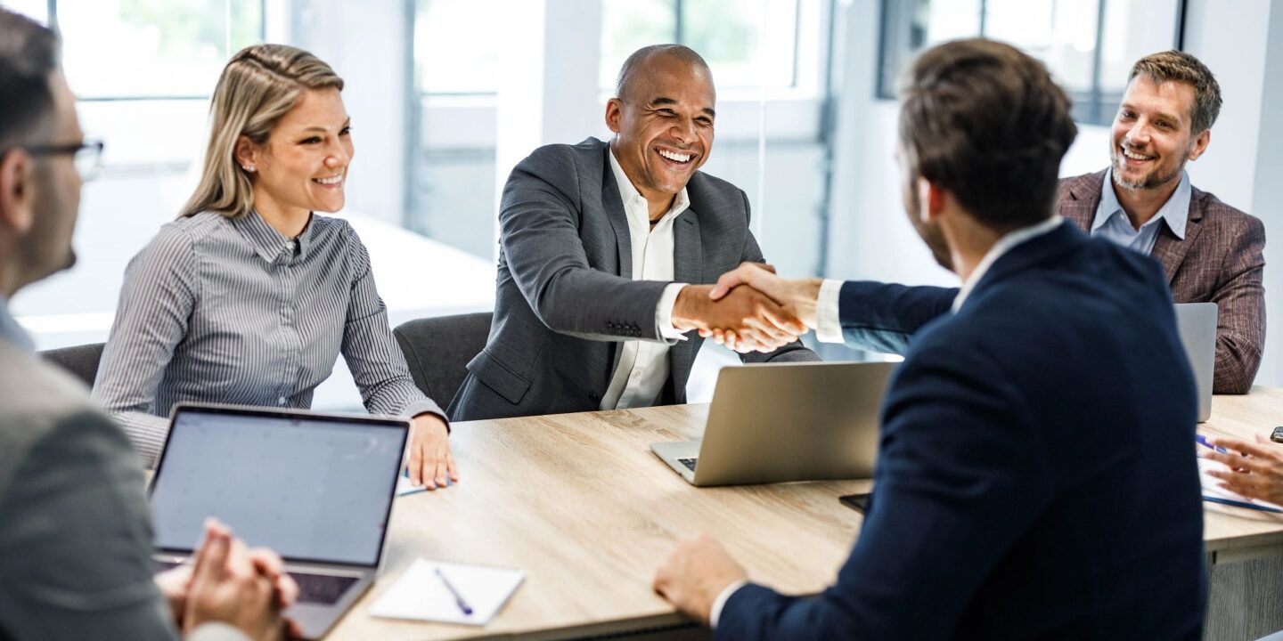 Happy businessmen shaking hands on a meeting in the office - Successful Preparation for a regulatory inspection:  What you need to know | NSF