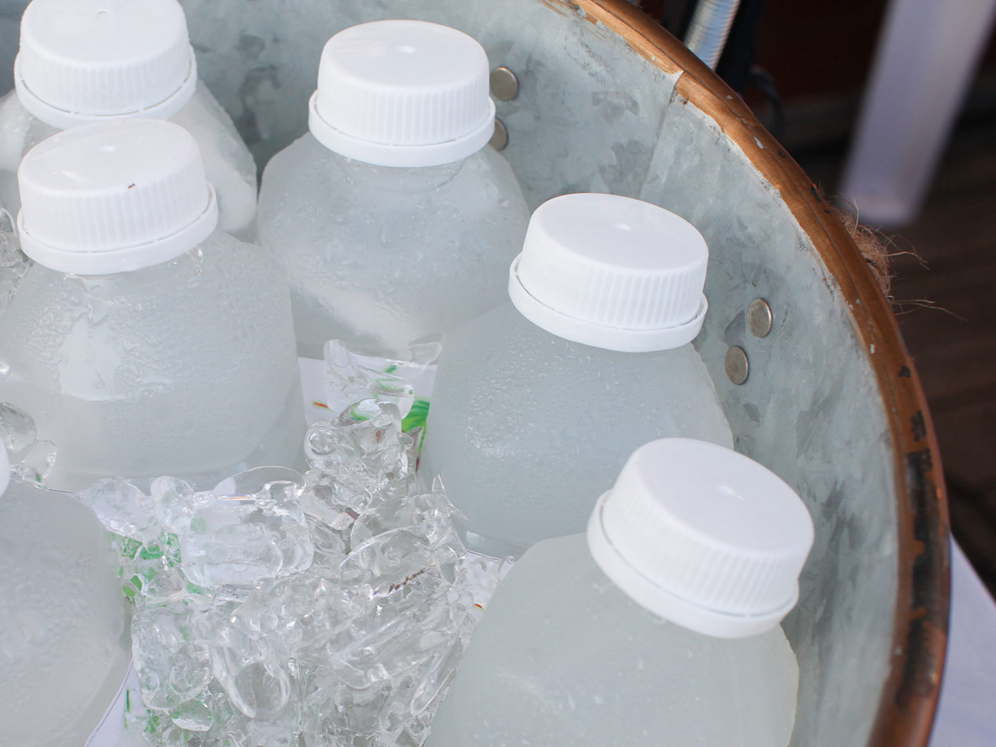 Bottled beverages packed in ice in a metal bucket