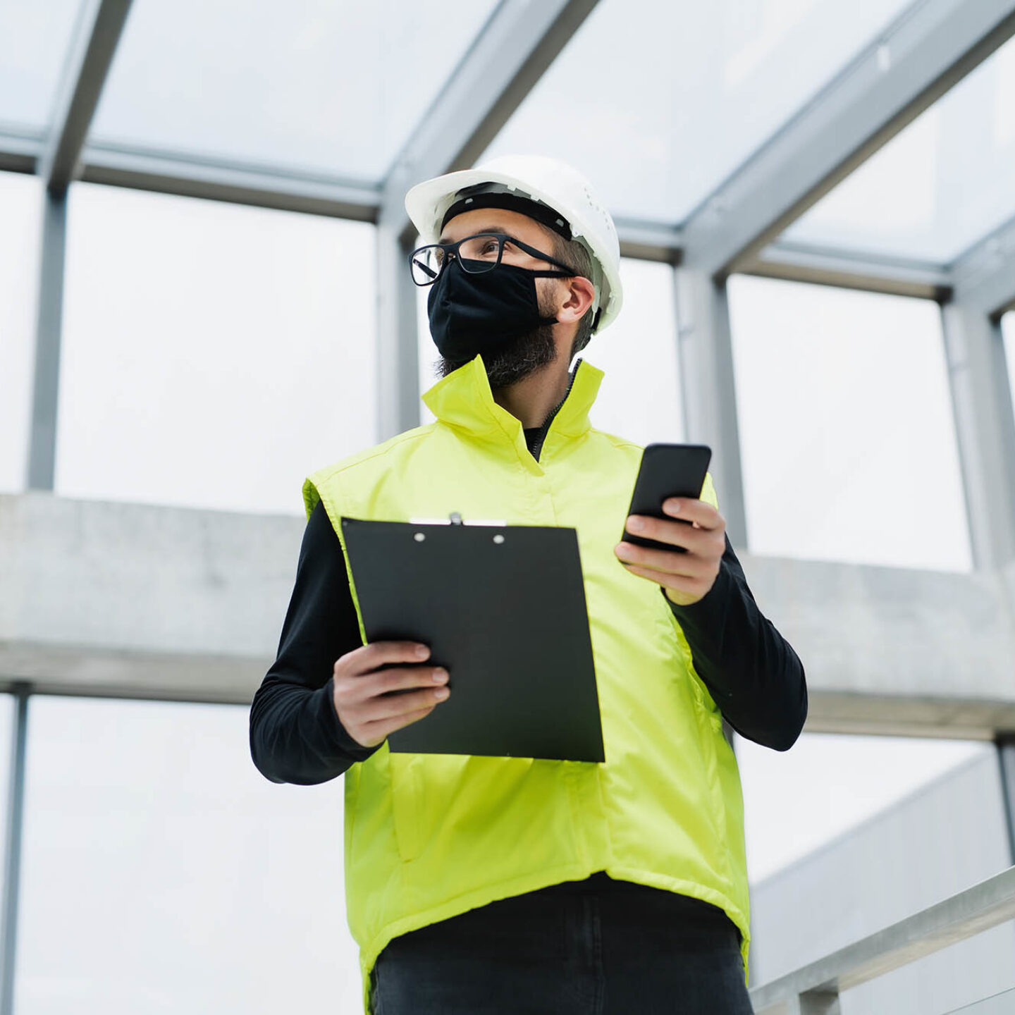 An image of a man wearing a mask, vest, and hardhat - NSF Work With a State to Help Promote COVID-19 Safety | NSF