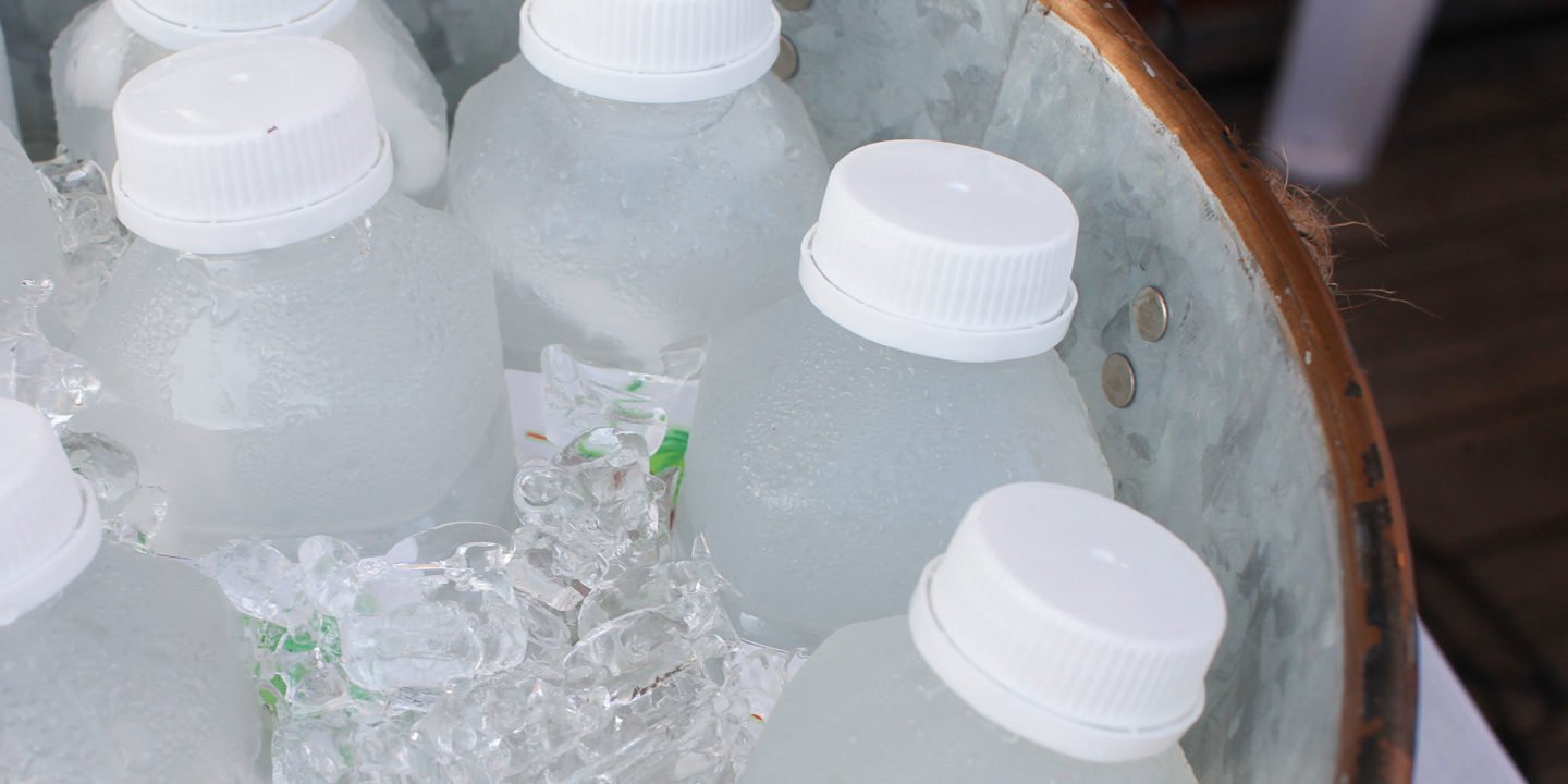 Bottled beverages packed in ice in a metal bucket