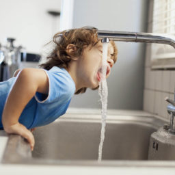 Boy drinking water from tap
