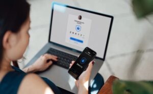 Woman on laptop and mobile device responds to two-step verification code – Information Security Management Systems | NSF