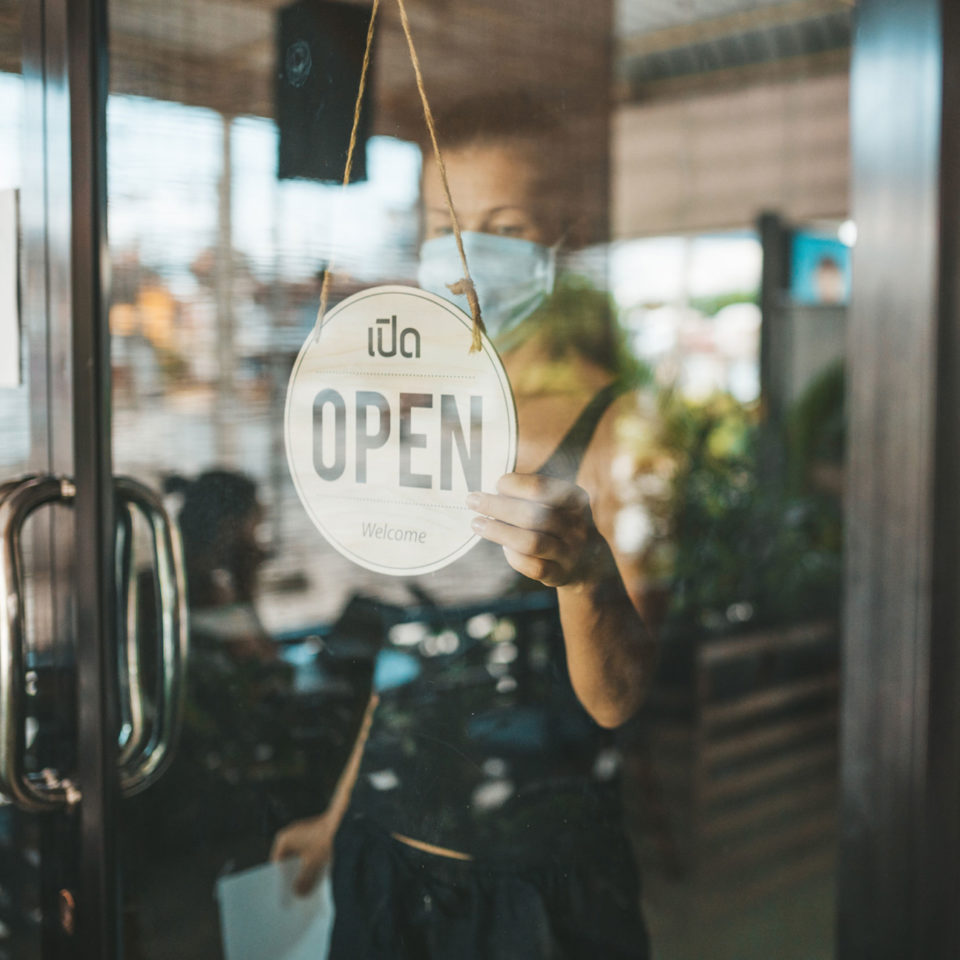 Business owner turning sign to open