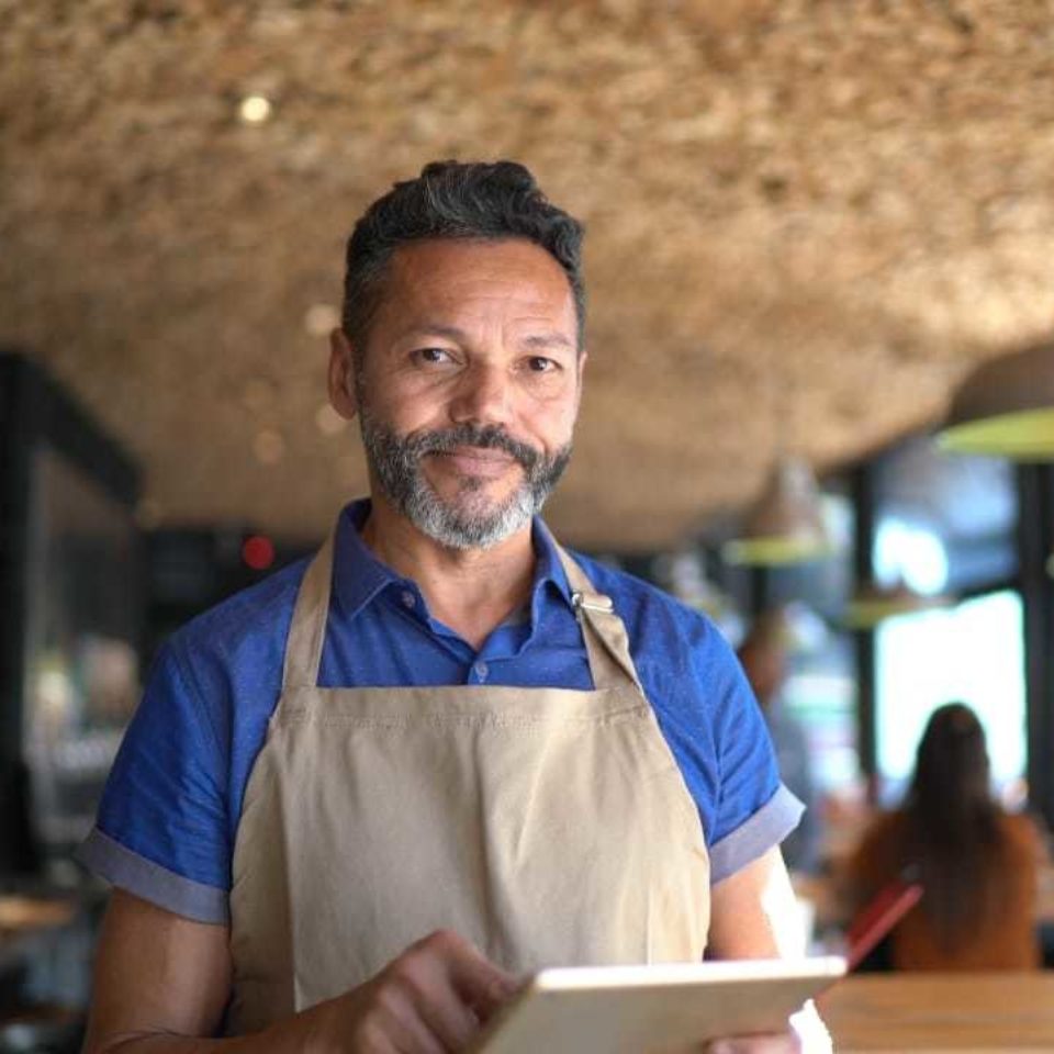 Man with tablet in restaurant - Leading You Forward | NSF International