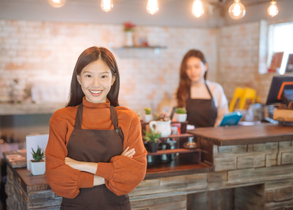 Asian restaurant owner with employee working in background