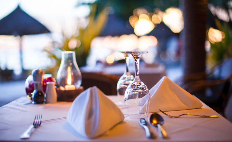 Outdoor restaurant table setting at dusk with cloth napikins