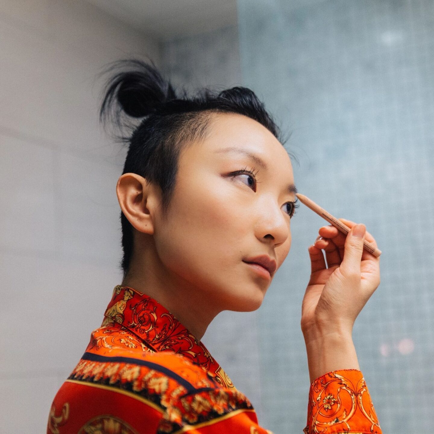 Woman looking into mirror while applying makeup - Wellness and Cosmetics | NSF