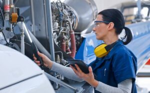 Female mechanic checking helicopter in aviation hangar - Transportation | NSF
